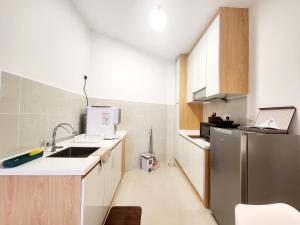 a small kitchen with a sink and a refrigerator at The Shore Kota Kinabalu City Centre by LW Suites in Kota Kinabalu