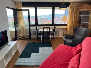 uma sala de estar com um sofá vermelho e uma mesa e cadeiras em Wohnung DC 12A em Neu-Ulm