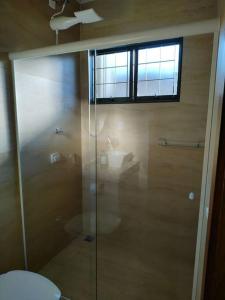 a glass shower in a bathroom with a toilet at Casa aconchegante in Sao Jose do Rio Preto