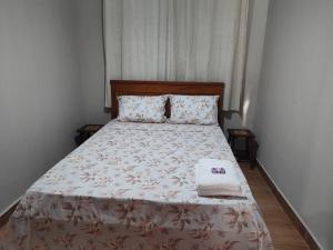 um quarto com uma cama com um edredão branco em Casa aconchegante em São José do Rio Preto