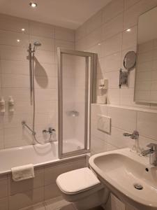 a bathroom with a shower and a toilet and a sink at Hotel Union in Offenburg +30 photos