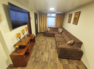 uma sala de estar com um sofá e uma televisão em Rooftop "Montalvo" em Baños