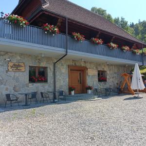 a building with a table and chairs in front of it at Górska Hacjenda in Brenna