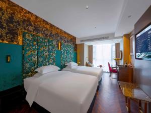 Habitación de hotel con 4 camas y pared con papel pintado colorido. en Zhangjiajie Metropolo Hotel, en Zhangjiajie