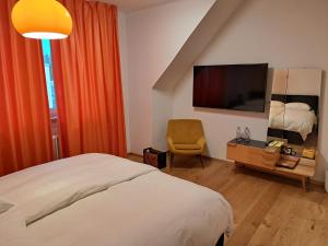 a bedroom with a bed and a tv and a chair at Hotel Union in Offenburg