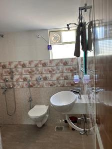 a bathroom with a toilet and a sink and a shower at James Guesthouse in Bogmolo