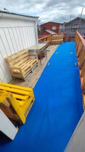 a deck with a blue floor and a table and benches at Comodo departamento in Puerto Montt