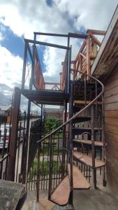 a wooden stairway with a bench next to a building at Comodo departamento in Puerto Montt