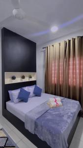 1 dormitorio con 1 cama grande con almohadas azules en KITA IMPIAN B-20-07, en Kampung Dengkil
