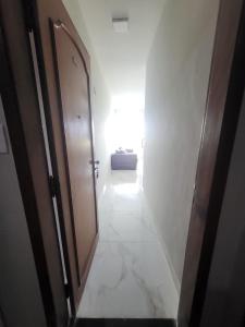 pasillo con puerta y lavabo en una habitación en Apê Gourmet Comfort, en Cuiabá