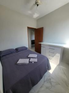 1 dormitorio con 1 cama con 2 toallas en Apê Gourmet Comfort, en Cuiabá