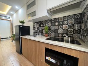 a kitchen with a stove and a refrigerator at Funhome Apartment Kim Ma Ha Noi in Hanoi