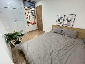 a bedroom with a bed and a potted plant at Funhome Apartment Kim Ma Ha Noi in Hanoi