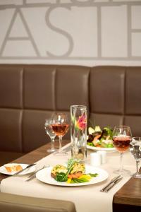 デュッセルドルフにあるノボテル デュッセルドルフ シティ ウエストのテーブル(2皿の食べ物とワイングラス付)