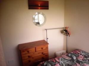 a bedroom with a bed and a dresser and a mirror at country retreat by the sea in Bessingby +1 photo