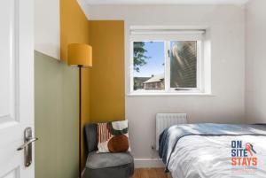 sypialnia z łóżkiem, krzesłem i oknem w obiekcie OnSiteStays - EARLY CHECK IN MAY - Modern 3 bed House, 2 x Parking, Garden, WIFI & dishwasher w mieście Bromley