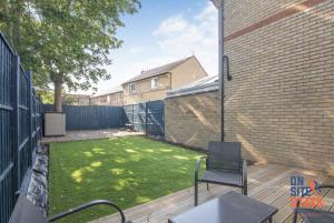 a small backyard with a deck with a lawn at OnSiteStays - EARLY CHECK IN AUGUST - Modern 3 bed House, 2 x Parking, Garden, WIFI & dishwasher in Bromley +20 photos