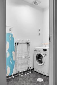 uma lavandaria com uma máquina de lavar roupa e uma máquina de lavar roupa em City Home Aurora em Tromsø