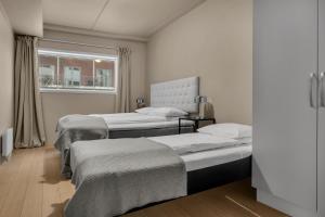 a bedroom with two beds and a window at City Home Aurora in Tromsø