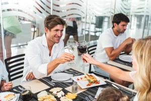 un groupe de personnes assises à une table avec des verres à vin dans l'établissement Hotel Villa del Mar, à Benidorm