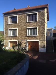 a brick house with a brown door and a staircase at appartement de 50m2 grand et spacieux avec jardin in Viry-Châtillon