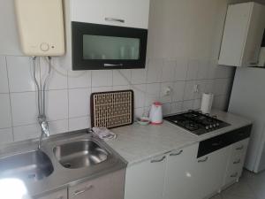 eine Küche mit einem Waschbecken und einem TV an der Wand in der Unterkunft Apartments Bella Vista Split in Split