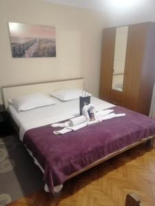 ein Schlafzimmer mit einem großen Bett mit einer lila Decke in der Unterkunft Apartments Bella Vista Split in Split