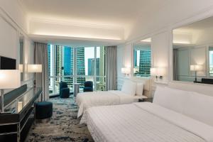 a hotel room with two beds and a large window at Le Meridien Mina Seyahi Beach Resort & Waterpark in Dubai +87 photos