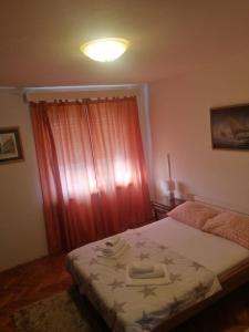 1 dormitorio con 1 cama con cortina roja en Apartments Bella Vista Split en Split