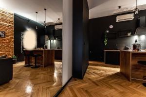Habitación con paredes negras, suelo de madera y mesas. en Krakowskie30 Loft2 na deptaku, en Lublin