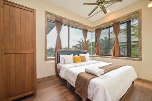 um quarto com uma cama e uma grande janela em Escape to ABS 3: Tranq Villas' 5Bedroom Pool Luxe Villa at Lonavala em Lonavala