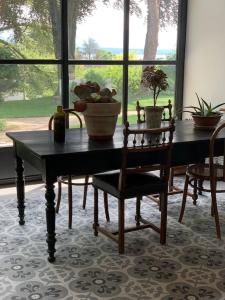 - une table et des chaises dans une chambre avec fenêtre dans l'établissement 'Le Petit Clos Suites'- Charming Garden Villa on Leman Lake, à Nyon