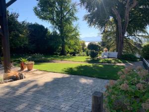 a garden with a brick walkway and trees and grass at 'Le Petit Clos Suites'- Charming Getaway on Leman Lake in Nyon