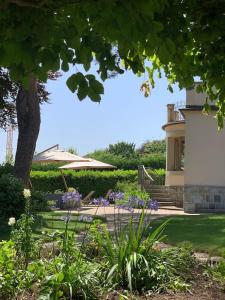 einen Garten mit lila Blumen und einem Haus in der Unterkunft 'Le Petit Clos Suites'- Charming Garden Villa on Leman Lake in Nyon