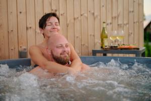 a man and a man in a hot tub at Cozy houses - Sauga Fishing Village riverside holiday center in Pärnu