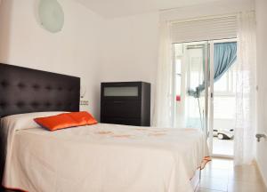 a bedroom with a bed with an orange pillow on it at COZY APARTEMENT VILLA CAPRI in Benidorm