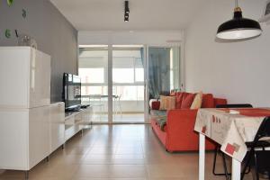 a living room with a red couch and a tv at COZY APARTEMENT VILLA CAPRI in Benidorm