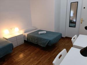 Habitación pequeña con 2 camas y espejo. en Sant Jordi Pisos - Consell de Cent en Barcelona