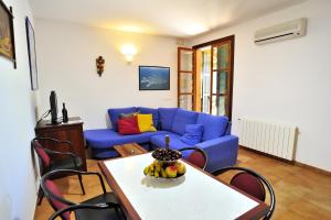 a living room with a blue couch and a table at Petit Hotel Es Figueral in Campos