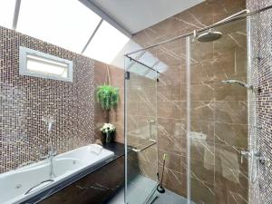 La salle de bains est pourvue d'une baignoire et d'une douche en verre. dans l'établissement Casa Collina Hua Hin - The Luxury Living at Hua Hin, à Hua Hin