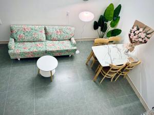 een woonkamer met een bank en een tafel en stoelen bij Local Me - Exclusive Centre Room in Hai Phong