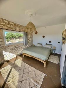 Chill House surf camp في سيدي كاوكي: غرفة نوم بسرير وجدار حجري