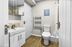 a white bathroom with a toilet and a sink at Whitsun 1,5 in Gosport