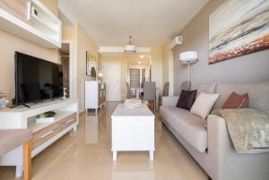 sala de estar con sofá y TV de pantalla plana en CASA AMANECER 1ªLinea de Playa Familiar, en Castellón de la Plana