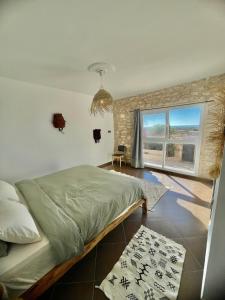 a bedroom with a bed and a large window at Chill House surf camp in Sidi Kaouki
