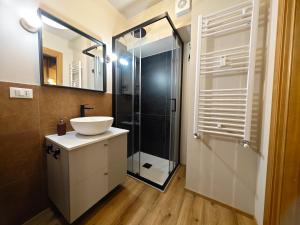 uma casa de banho com um lavatório e um chuveiro em Hostdomus - Il Cerbiatto Apartment em Sestriere