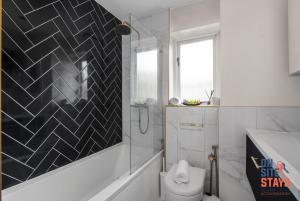 W łazience znajduje się toaleta i przeszklony prysznic. w obiekcie OnSiteStays - EARLY CHECK IN MAY - Modern 3 bed House, 2 x Parking, Garden, WIFI & dishwasher w mieście Bromley