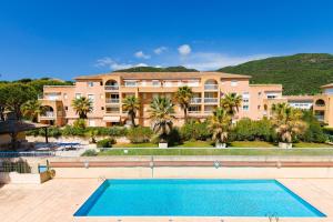 un grand immeuble avec une grande piscine dans l'établissement Lagrange Vacances Villa Barbara, à Cavalaire-sur-Mer