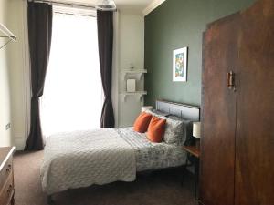 um quarto com uma cama com almofadas laranja e uma janela em Apartment One Hull em Hull