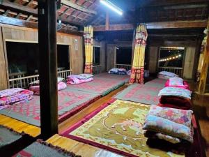 een kamer met drie bedden in een kamer met een tapijt bij Homestay Chung Thúy in Ha Giang